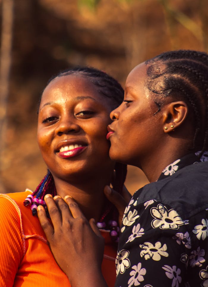 Two women share a joyful and intimate moment outdoors, symbolizing friendship and happiness.